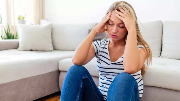 A person looking thoughtfully at a handful of healthy foods.